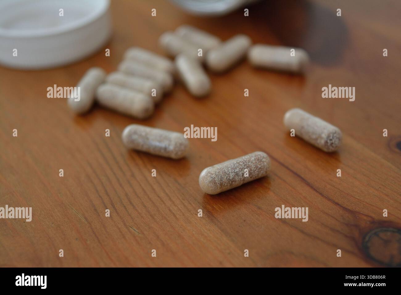 Ergänzungskapseln, die auf einer Holzplatte verschüttet werden 3 Stockfoto