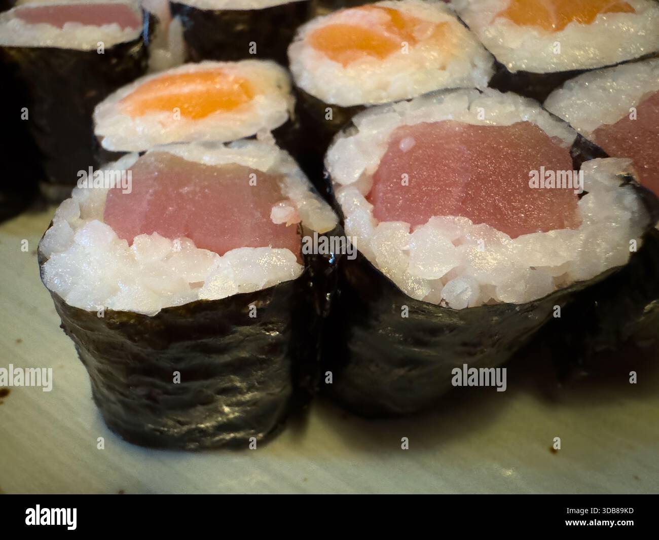 Frisch zubereitete Thunfisch- und Lachs-Maki-Sushi-Brötchen mit Reis und Nori-Algen Stockfoto