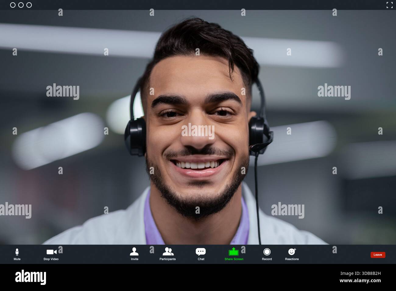 Mann mit Headset lächelt während eines Videoanrufs in moderner Büroumgebung Stockfoto