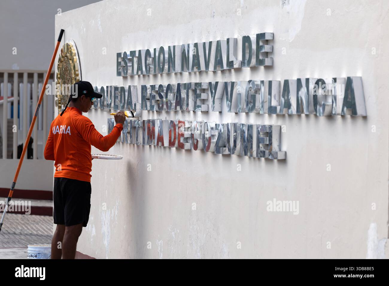 Ein Wartungspersonal malt Schriften an der Wand einer mexikanischen Marine-Einrichtung in Cozumel, Mexiko. Stockfoto