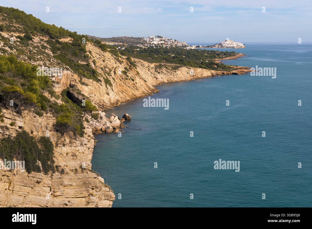 Entdecken Sie die atemberaubende natürliche Schönheit von Peniscola, wo zerklüftete Klippen unter hellem Himmel auf das azurblaue Meer treffen, perfekt für einen friedlichen Kurzurlaub in Spanien Stockfoto