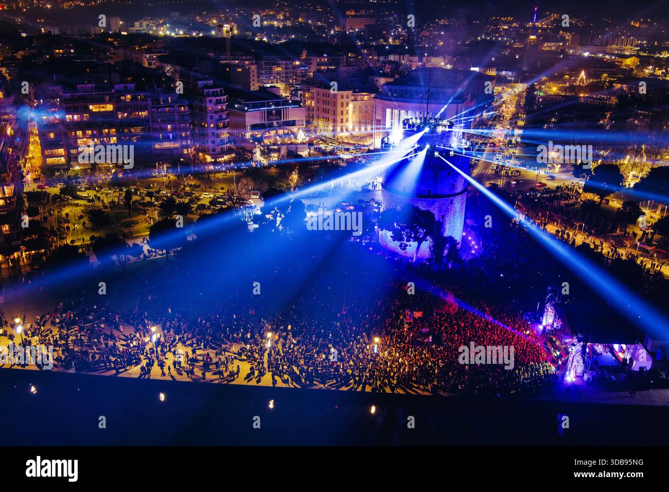 Thessaloniki, Griechenland, 31. Dezember 2024: Der Weiße Turm leuchtet mit leuchtenden Lichtern, während die Strahlen in den Nachthimmel strahlen und damit die Neujahrsreise der Stadt markieren Stockfoto