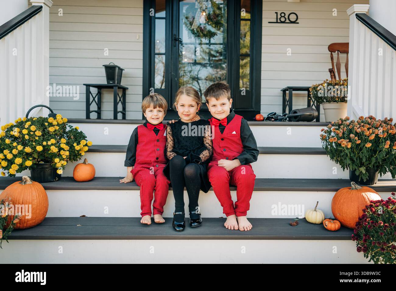 Kinder posieren für Familienporträt auf der Herbstveranda Stockfoto