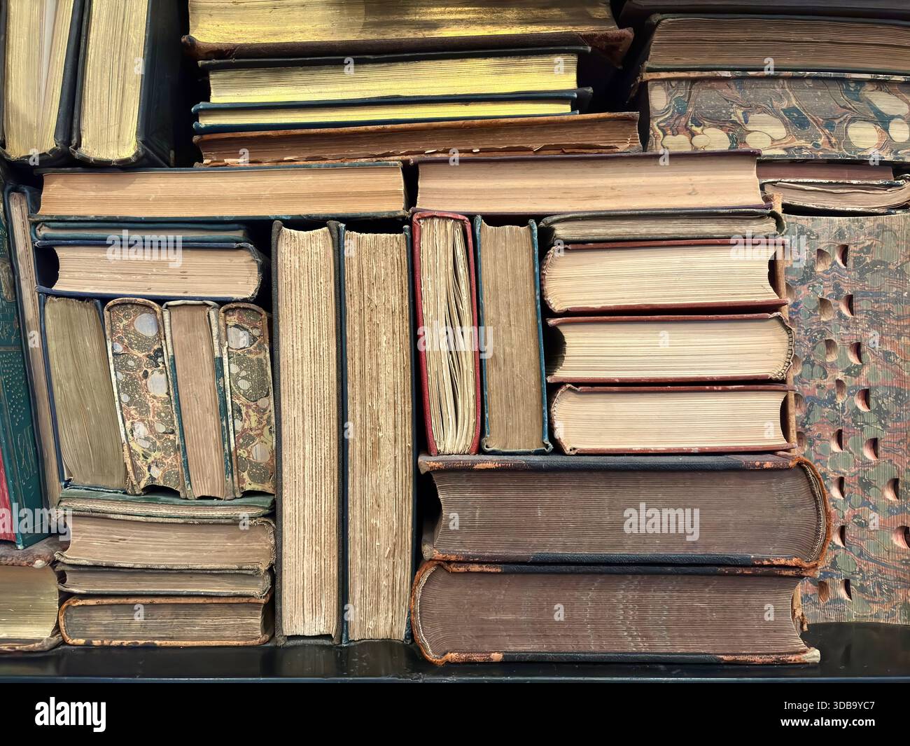 Eine dichte Sammlung von antiken und Vintage-Büchern in einem Regal Stockfoto