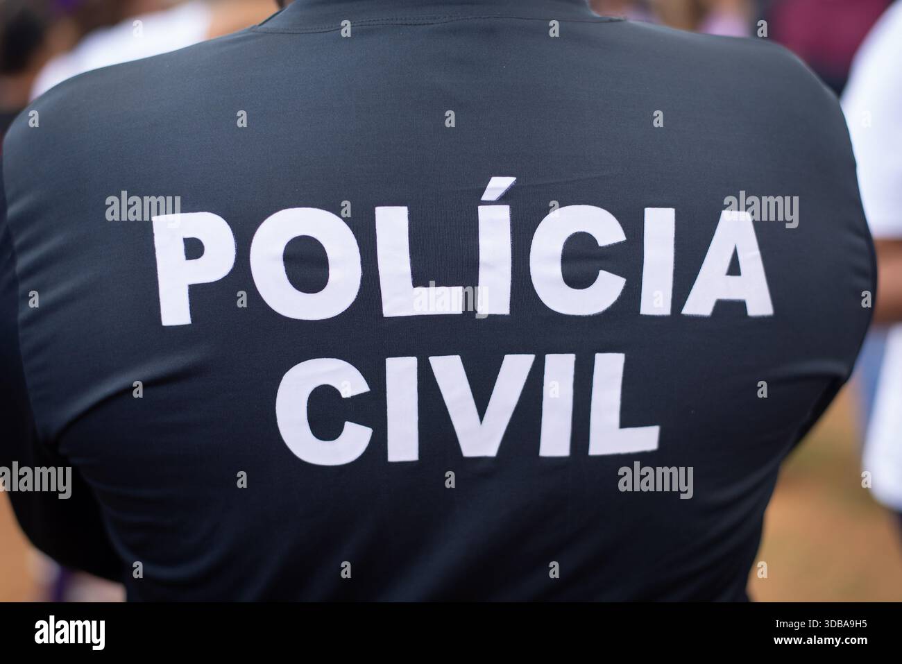 Nahaufnahme der Rückseite eines schwarzen T-Shirts eines Polizisten mit den Worten Polícia CIVIL in den weißen Buchstaben d Stockfoto