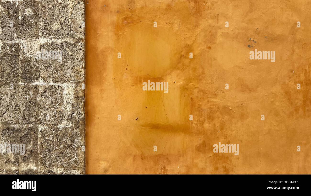 Alte Außenwand des Hauses gelb gestrichen mit dekorativen Fliesen und verwitterter Textur. Architektonische Details eines traditionellen Wohngebäudes Stockfoto