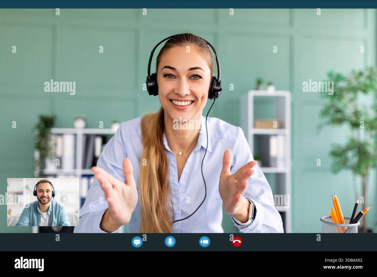 Junge Frau führt produktive Videogespräche mit Kollegen aus ihrem Office Workspace Stockfoto