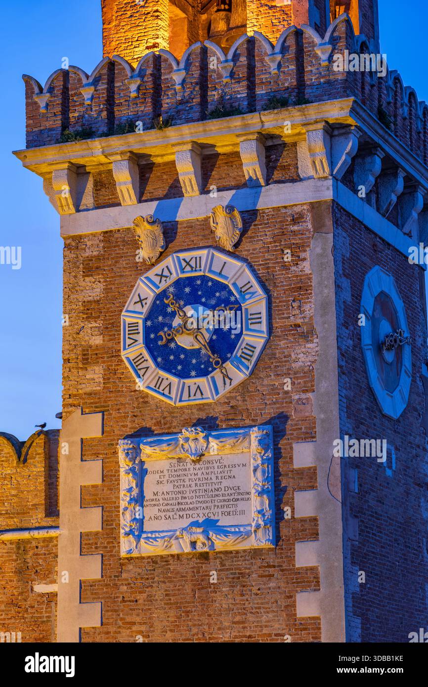 Uhr mit römischen Zahlen auf venezianischem Arsenal (italienisch Arsenale di Venezia) Turm bei Dämmerung in Venedig, Italien. Stockfoto
