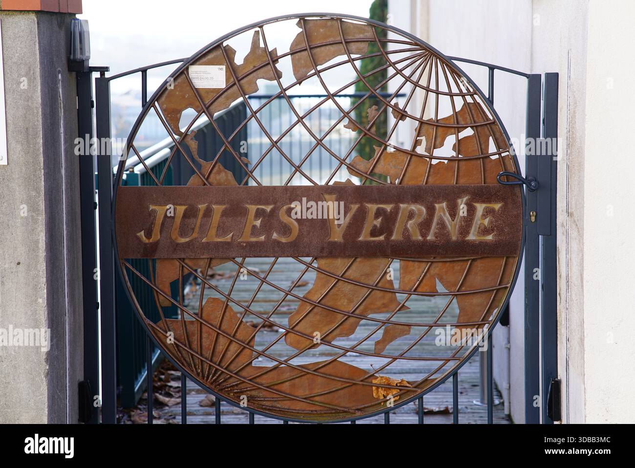 Dekoratives Metalltor mit Kugeldesign und dem Namen Jules Verne an einem Eingang. Nantes, Frankreich Stockfoto