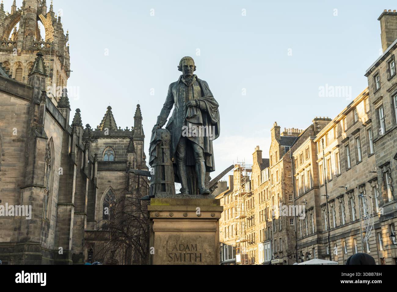 Der Blick auf Adam Smiths Statue steht stolz vor dem Hintergrund historischer Steinbauten unter einem hellen Himmel und fängt einen Moment in der Zeit ein, Edinburgh, S Stockfoto
