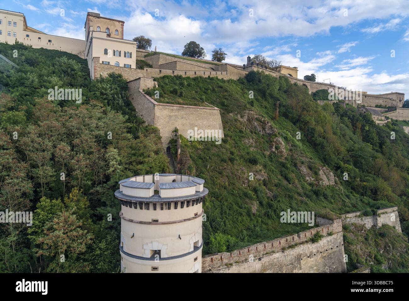 Blick auf die majestätische Festung Ehrenbreitstein auf einem grünen Hügel, deren Steinmauern sich vom üppigen Grün abheben, Koblenz, Deutschland. Stockfoto