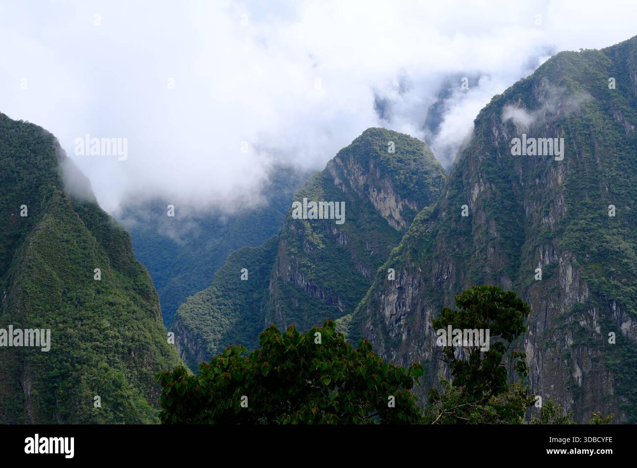 Wolken treiben durch steile grüne Berge in den Anden in der Nähe von Machu Picchu, Peru Stockfoto