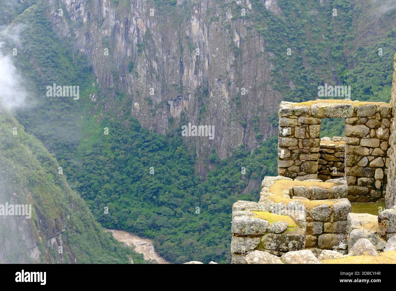Inka-Ruinen mit Blick auf ein tiefgrünes Tal und Fluss bei Machu Picchu in den Anden von Peru Stockfoto