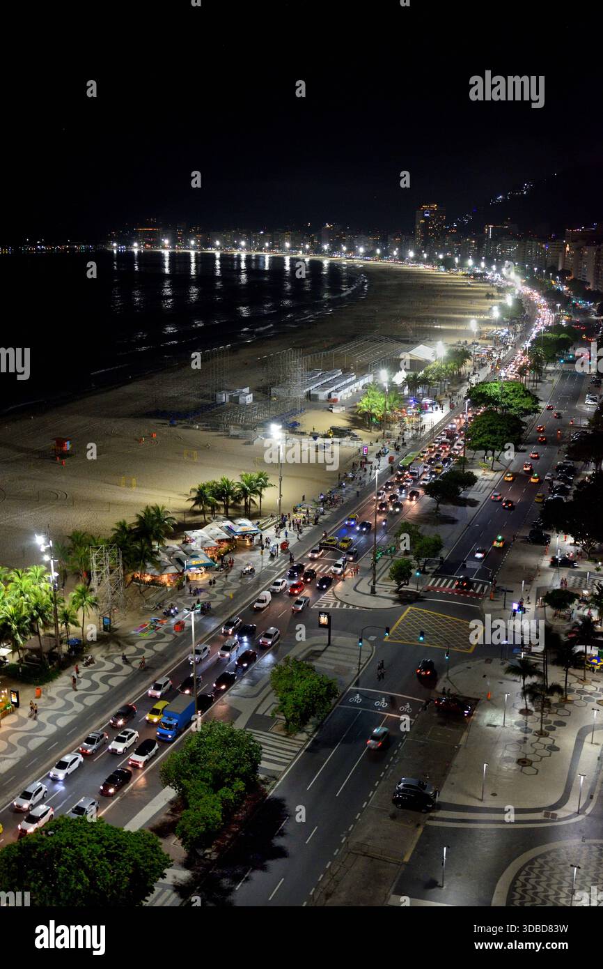 Der Abendverkehr schleicht in Richtung Norden entlang der Avenida Atlantica am Strand von Copacabana in Rio de Janeiro, Brasilien. Stockfoto