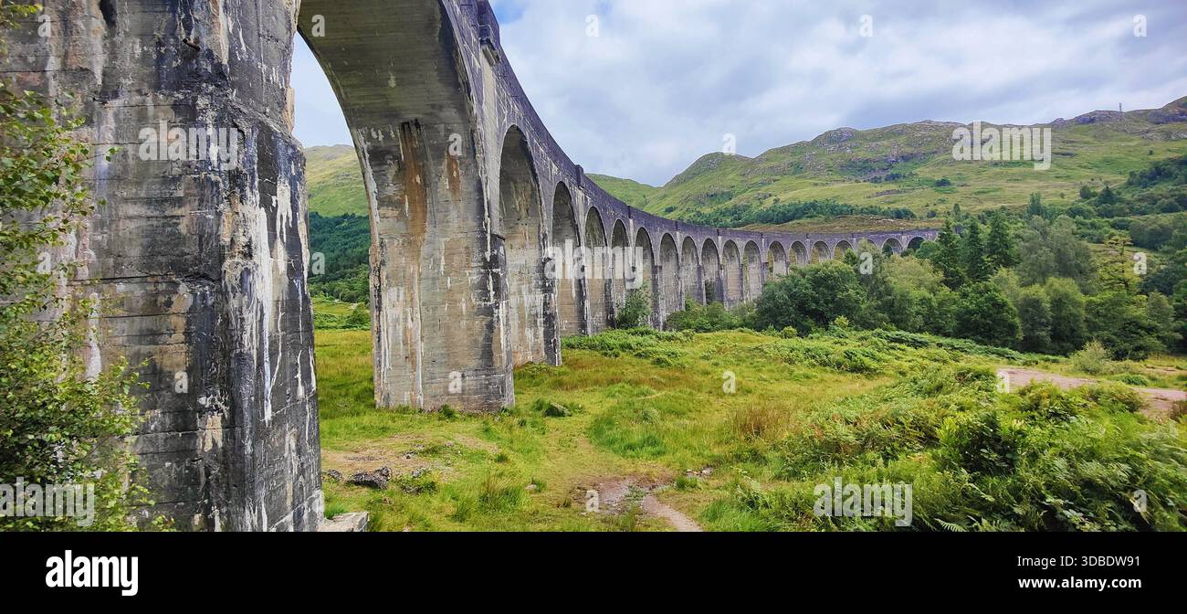Ein atemberaubender Blick auf das legendäre Glenfinnan Monument in den schottischen Highlands, berühmt aus der Harry-Potter-Saga, inmitten einer majestätischen Landschaft. Stockfoto
