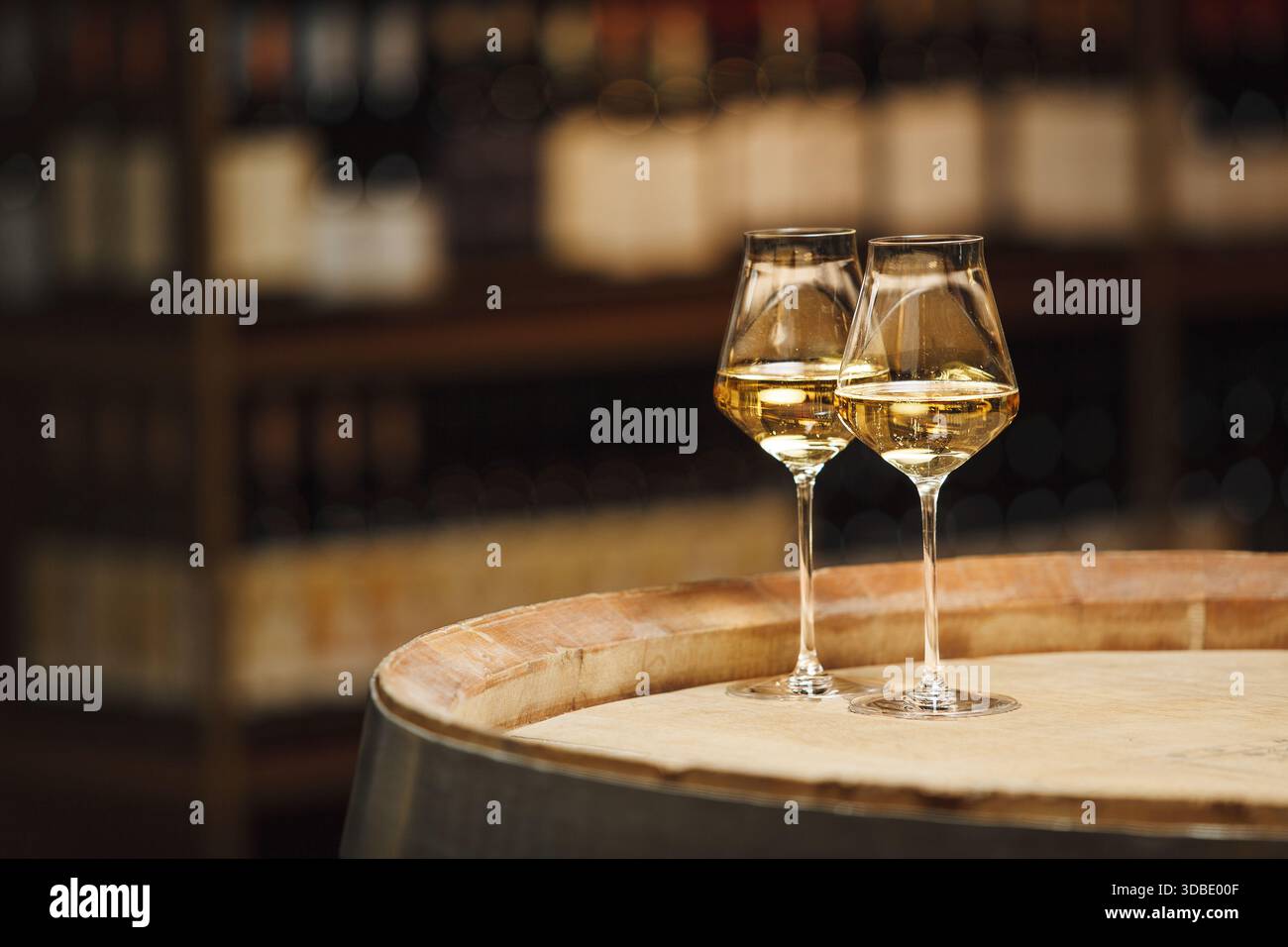 Zwei Gläser Weißwein auf Holzfässern im Weingut Stockfoto