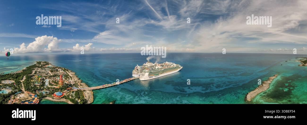 Aus der Vogelperspektive auf das türkisfarbene Wasser, das die Kreuzfahrtschiffe umgibt, die am lebhaften Pier nahe dem Inselresort Nassau, Bahamas angedockt sind. Stockfoto