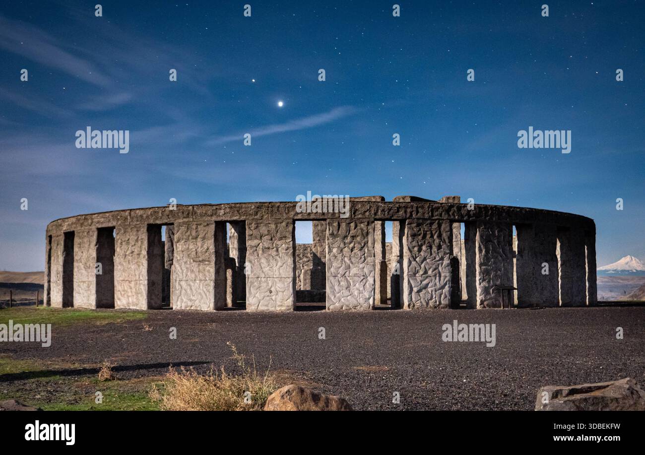 Blick auf Steinmonolithen, die sich gegen den Nachthimmel erheben, gekrönt von einem hellen Stern, in einer ruhigen Landschaft, die ein Gefühl von Mysterium und altem Wunder weckt. Stockfoto
