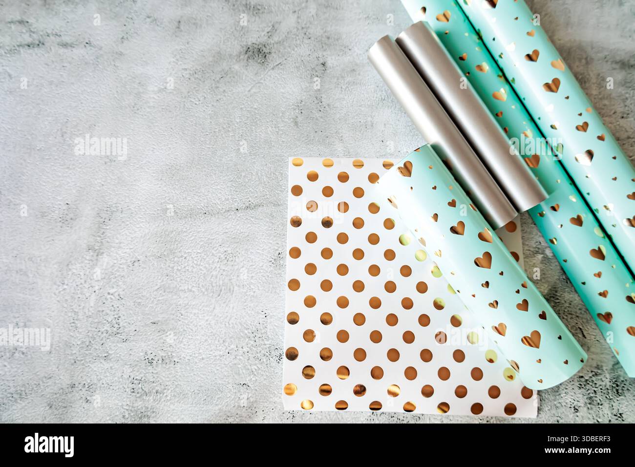 Draufsicht auf verschiedene Geschenkpapiere in sanften Farben und festlichen Designs. Ideal für Verpackungen, Geschenkkonzepte und saisonale Designprojekte Stockfoto