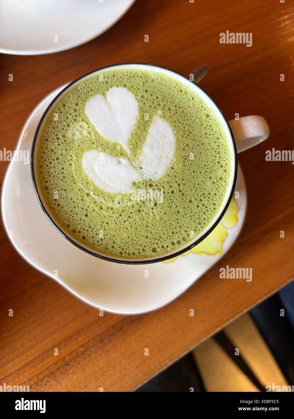 Eine Tasse grüner Tee-Latte mit Kunst - Smartphone-aufgenommenes Stockfoto