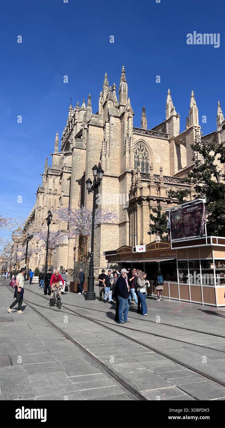 Grandioser gotischer Eingang der Kathedrale von Sevilla in Spanien, ein historisches andalusisches Wahrzeichen mit kunstvollem Steinmetzwerk und Stadtleben. Stockfoto
