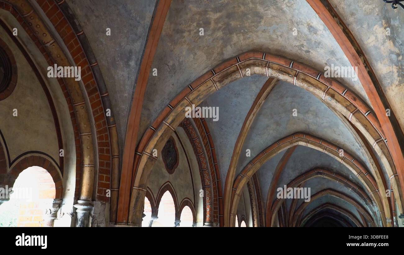 Ein detaillierter Blick auf eindrucksvolle frühgotische Rippengewölbe und Bogendecken im Rigaer Dom. Alte Steine und Ziegelsteine zeigen die Grandeu Stockfoto