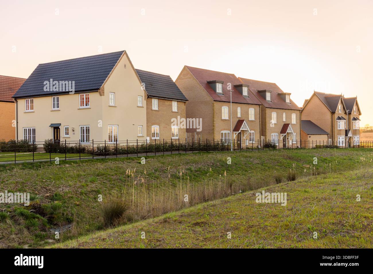 Reihe neuer Häuser in einer Wohnsiedlung in England bei Sonnenuntergang im Frühjahr Stockfoto