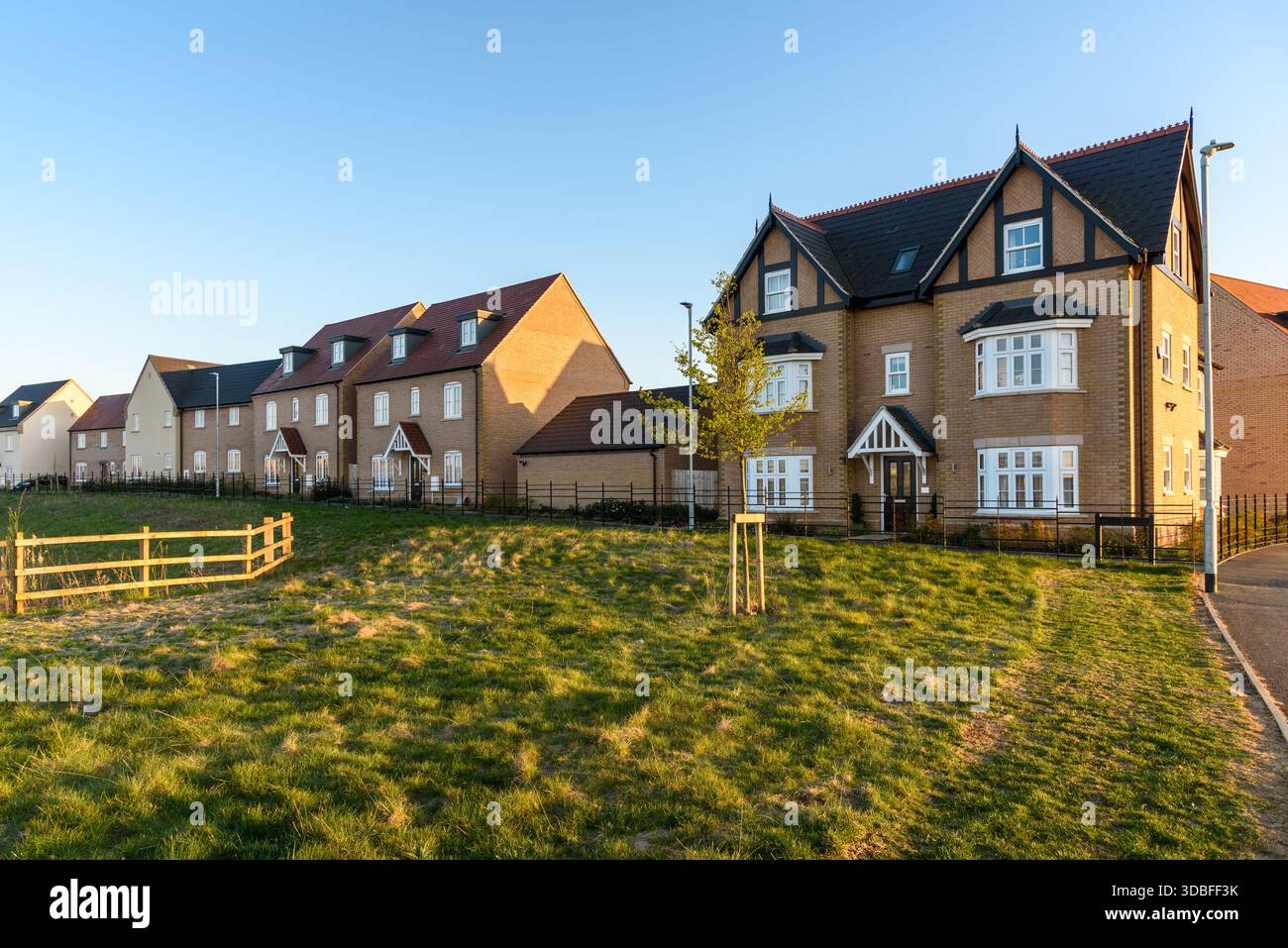 Neue Häuser in einer Vorstadtsiedlung in England bei Sonnenuntergang im Frühjahr Stockfoto