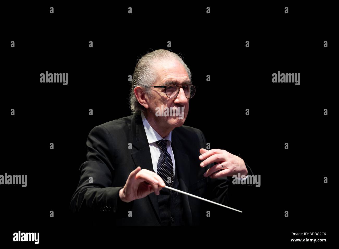 Der belgische Staatsmann Willy Claes, ein renommierter ehemaliger Politiker und ehemaliger Generalsekretär der NATO, ist Gastdirigent des VUB Orchesters in C‑Mine i Stockfoto