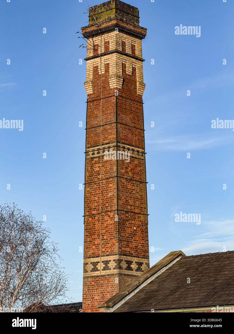 Ein Tall Industrial Brick Build Chimney war einst Teil der Firma T. Wragg and Sons Pipework Company mit Sitz in Swadlincote Derbyshire - Smartphone-aufgenommenes Stockfoto