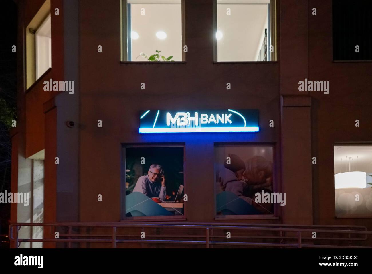 Ausschilderung der MBH-Bank in der Dunakorzó-Straße in Szentendre – beleuchtete Ladenfront und Geldautomat bei Nacht. Stockfoto
