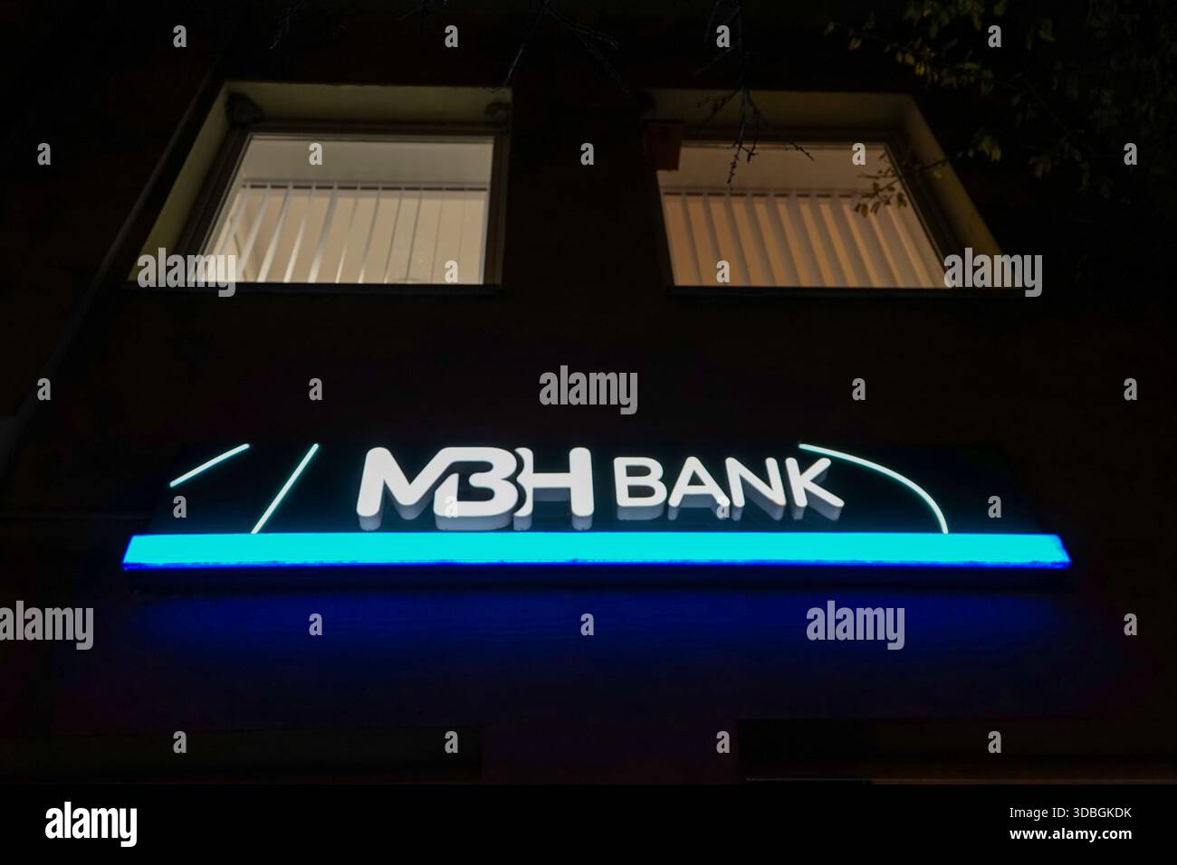 Ausschilderung der MBH-Bank in der Dunakorzó-Straße in Szentendre – beleuchtete Ladenfront und Geldautomat bei Nacht. Stockfoto