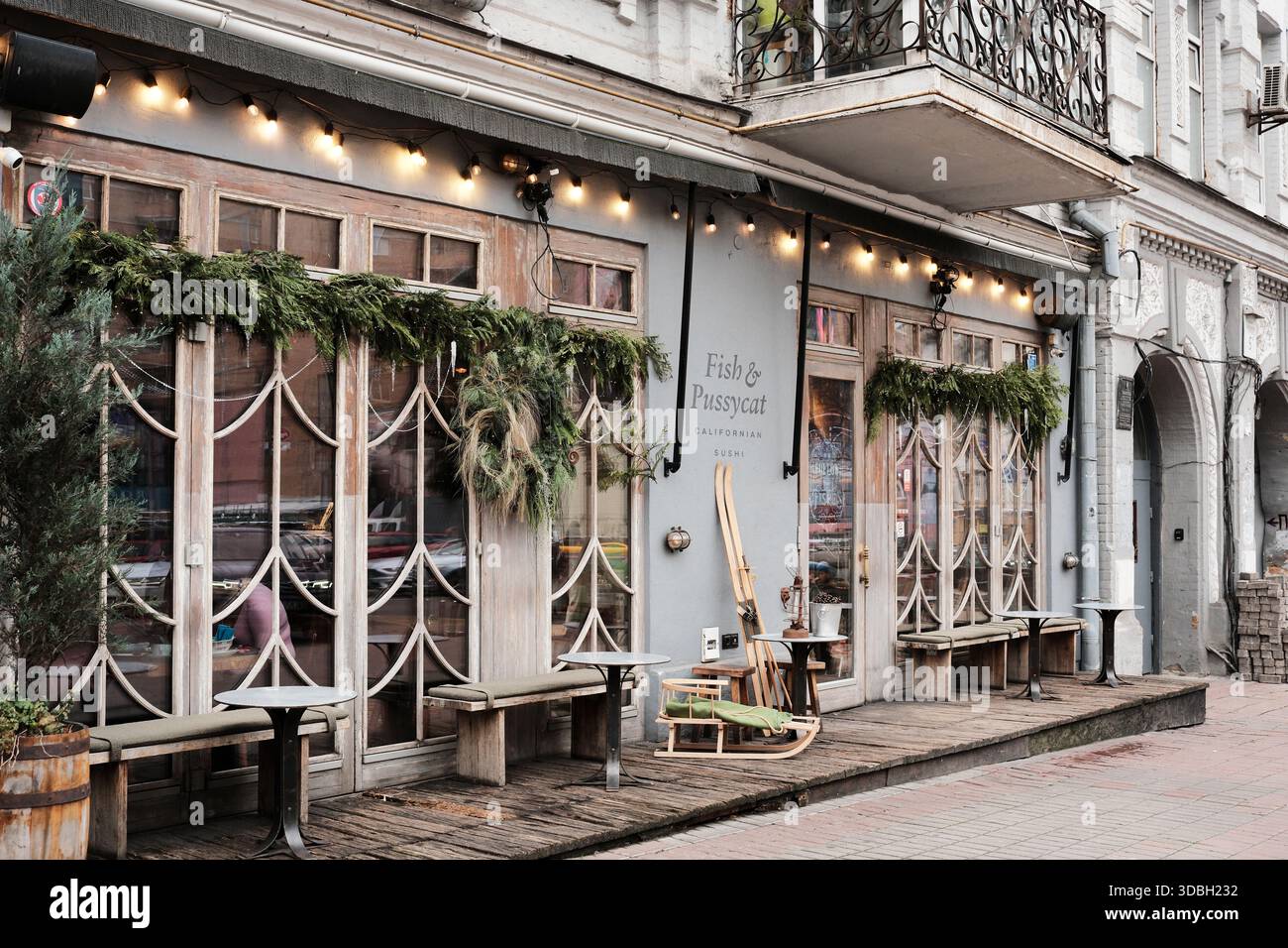 Ein gemütliches Restaurant mit elegantem Dekor lädt Gäste ein, sich im Freien in der Stadt zu entspannen. Kiew, Ukraine. Dezember 2025. Stockfoto