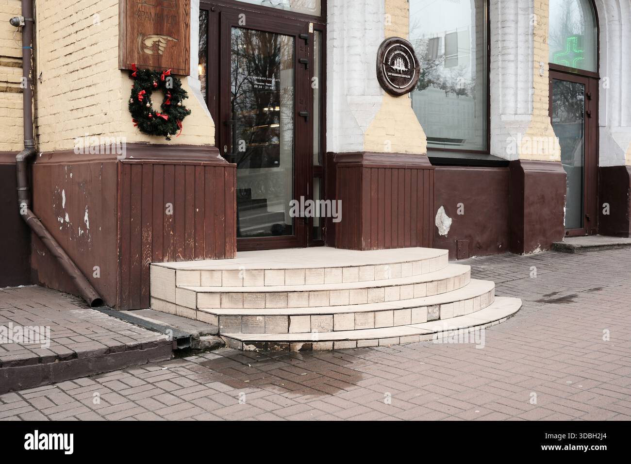 Ein atemberaubender Gebäudeeingang mit Weihnachtsdekorationen, die Besucher einladen. Shevchenko Boulevard. Kiew, Ukraine. Dezember 2025. Stockfoto