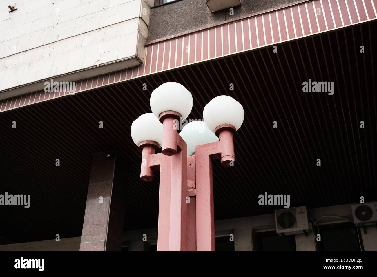 Eine moderne Straßenlaterne mit geschwungenen Kugeln steht vor der Fassade eines Gebäudes. Shevchenko Boulevard. Kiew, Ukraine. Dezember 2025. Stockfoto