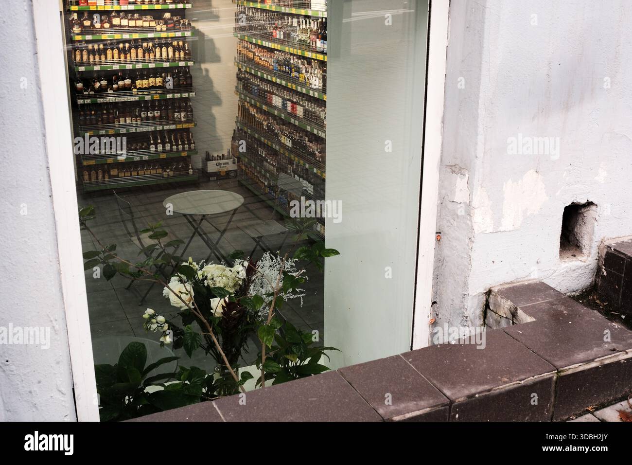 Eine wunderschöne Ladenfront zeigt farbenfrohe Flaschen und ein heiteres Blumenarrangement. Shevchenko Boulevard. Kiew, Ukraine. Dezember 2025. Stockfoto