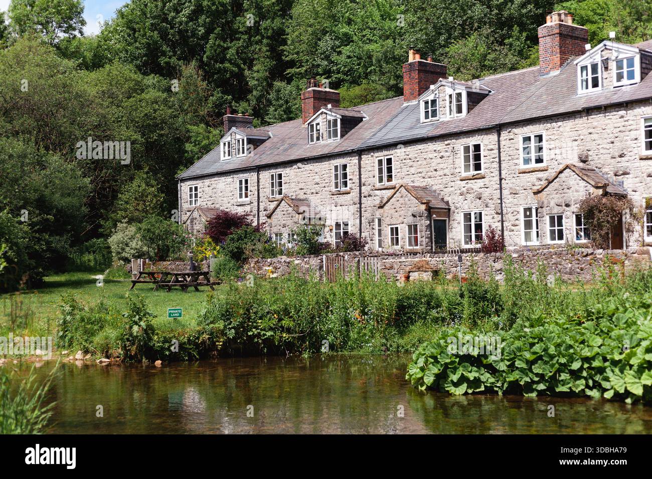 Traditionelle Steinhäuser neben einem Fluss im ländlichen England Stockfoto
