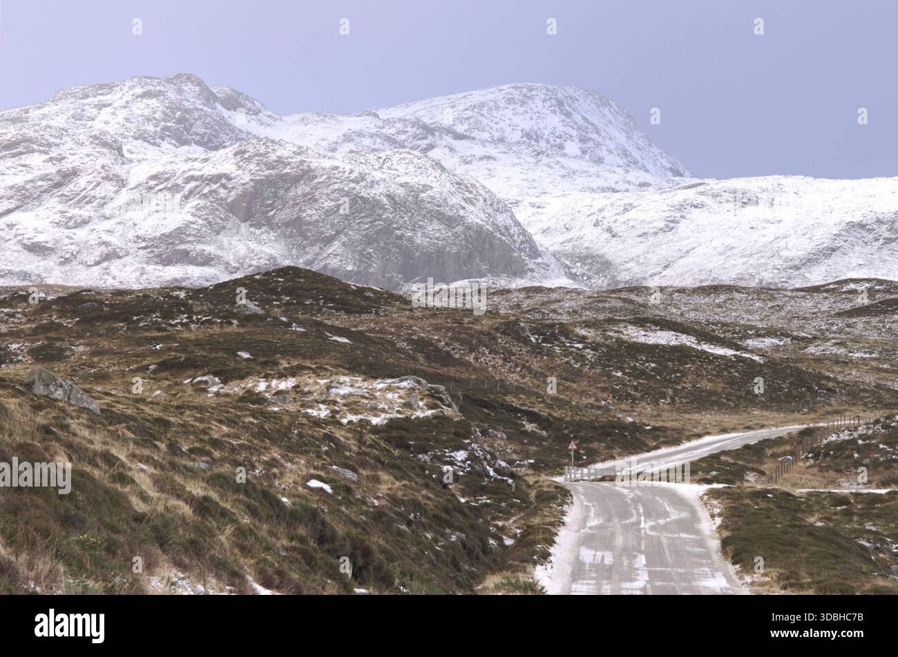 Schneebedeckte Straße zu den schneebedeckten Bergen der Isle of Harris in den Äußeren Hebriden Schottland Stockfoto