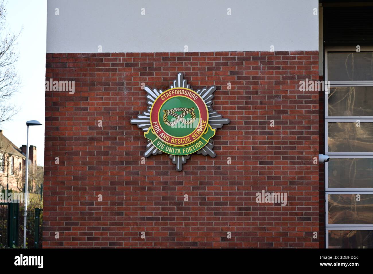 Lichfield, Vereinigtes Königreich - 10. Dezember 2025: Staffordshire Fire and Rescue Emblem auf Brick Wall Exterior Stockfoto