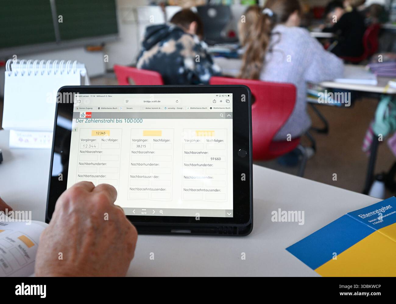 PRODUKTION - 05. November 2025, Baden-Württemberg, Stuttgart: In einer Grundschule arbeitet ein Lehrer der vierten Klasse an einem digitalen Whiteboard-System, während die Schüler im Klassenzimmer sitzen. Foto: Bernd Weißbrod/dpa Stockfoto