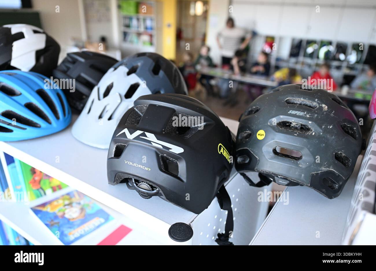 PRODUKTION - 05. November 2025, Baden-Württemberg, Stuttgart: Fahrradhelme liegen auf einem Regal in einer 4. Klasse. Foto: Bernd Weißbrod/dpa Stockfoto
