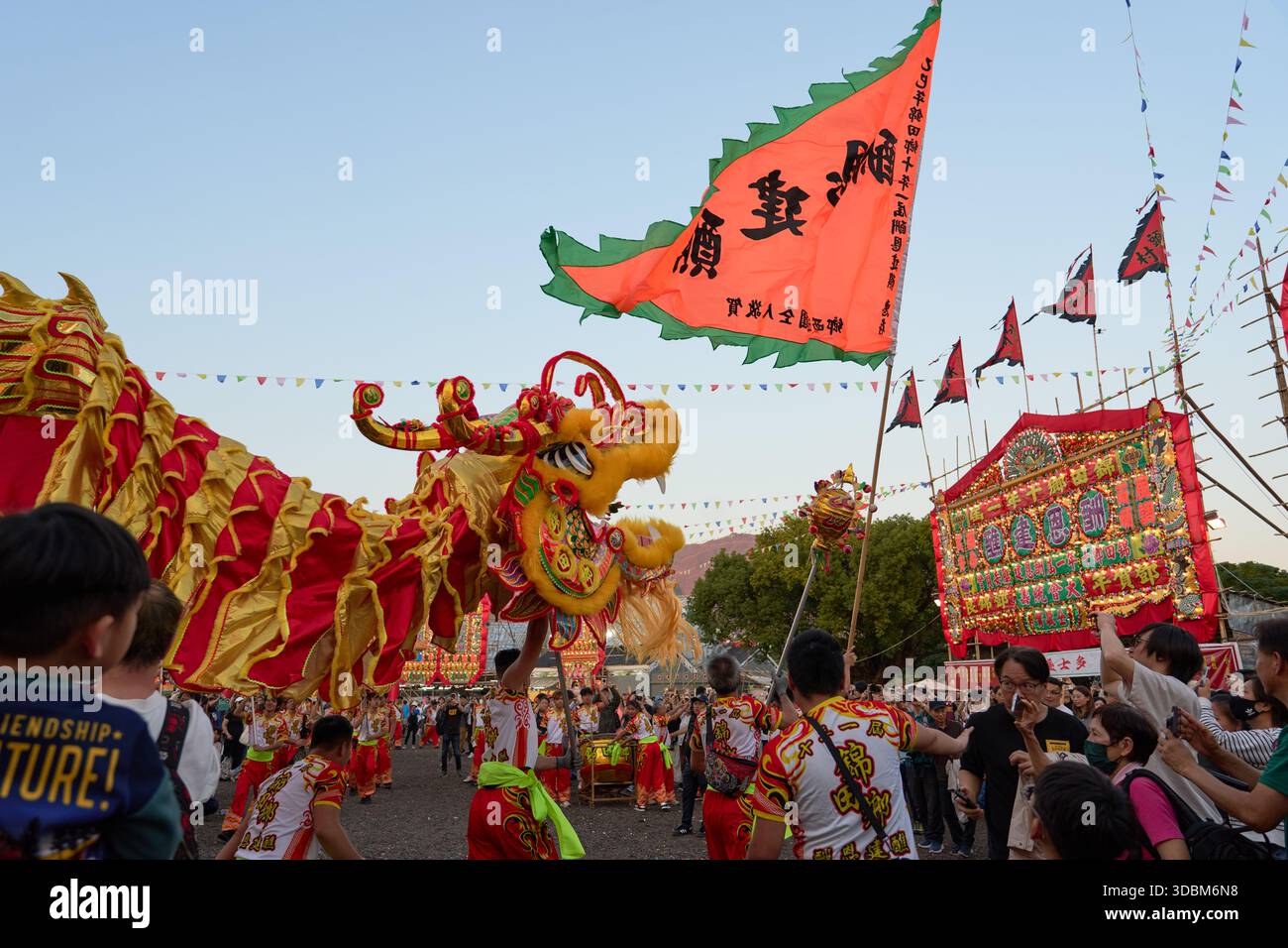 Szene beim 34. Kam Tin Jiao Festival - Drachentanz, Flaggen, Bambusstrukturen und Zuschauer, Teil des dankbaren Gottesrituals von kam Tin Heung. Stockfoto