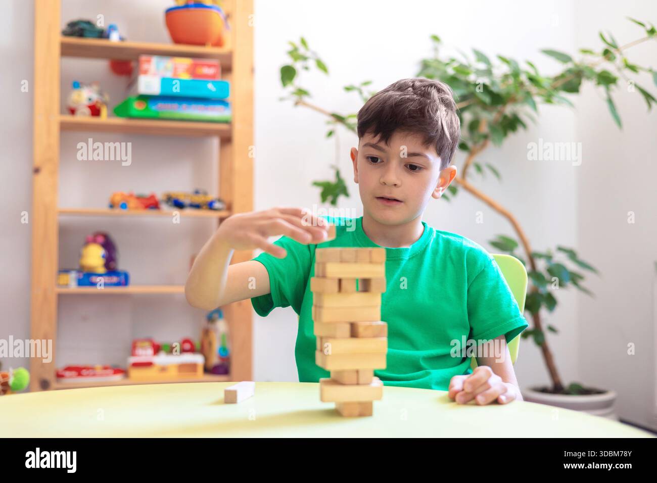 Kinderbau Holzblockturm: Therapeutisches Spiel für kognitive und motorische Entwicklung. Aktivitäten für Kinder mit psychischen Störungen. Hirnentwicklung Stockfoto