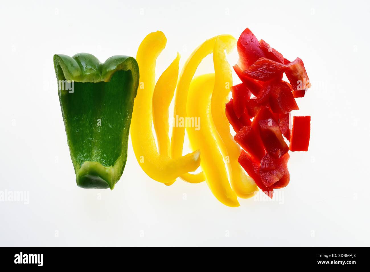 Grüne, gelbe und rote Paprika in Viertel, Streifen und Stücke auf weißem Hintergrund geschnitten Stockfoto