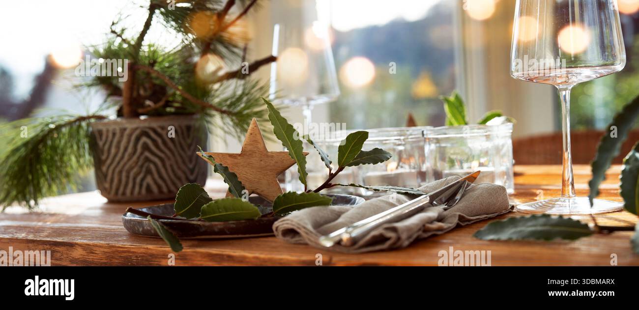 Stimmungsvolle weihnachtsdekoration in einem gemütlichen Wintergarten mit festlichen Bokeh-Lichtern. Romantisches weihnachtsessen mit Kerzen in einem Restaurant. Horizontaler Gastronomie-Hintergrund. Stockfoto