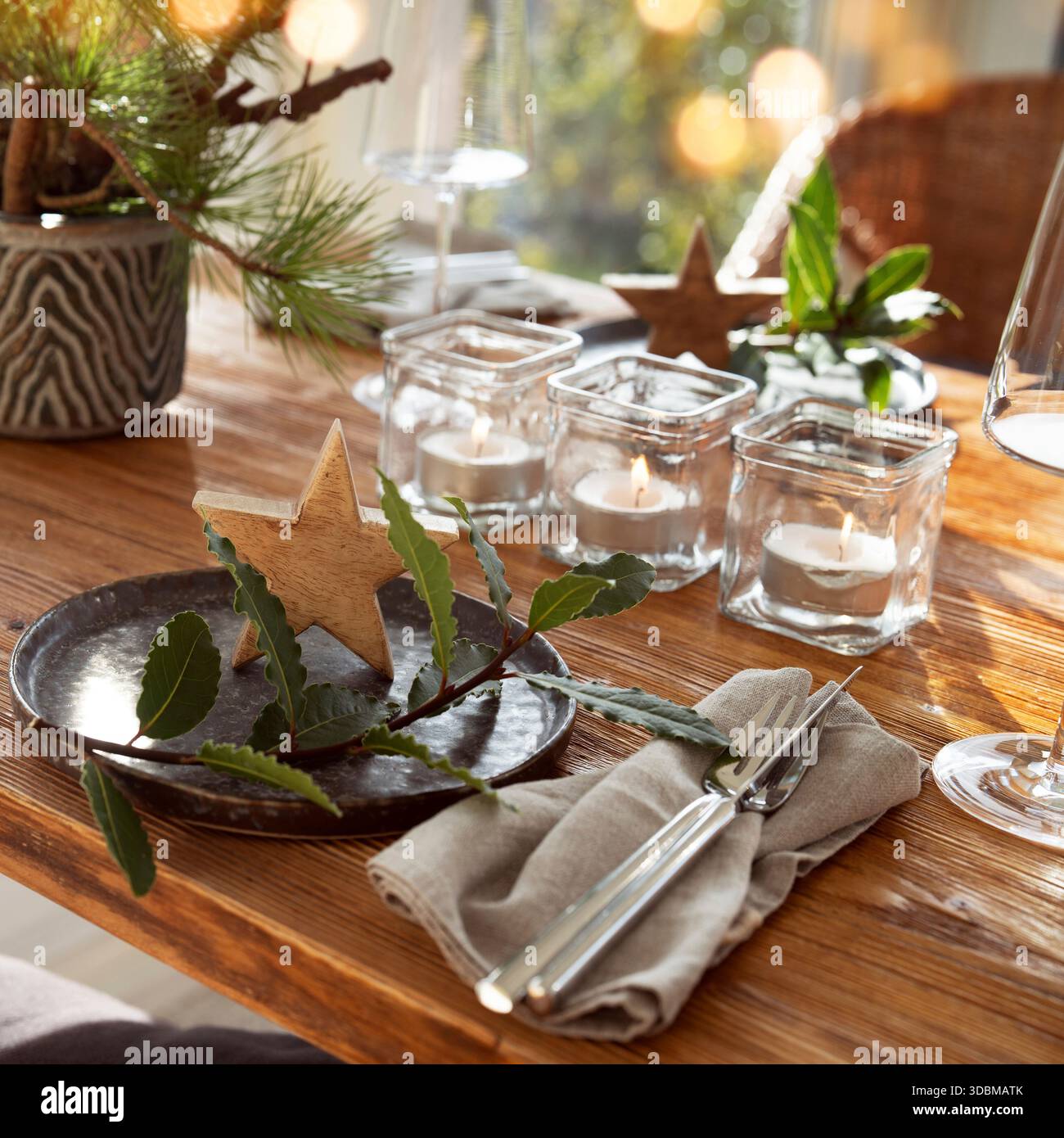 Stimmungsvolle weihnachtsdekoration in einem gemütlichen Wintergarten mit festlichen Bokeh-Lichtern. Romantisches weihnachtsessen mit Kerzen in einem Restaurant. Gastronomie Hintergrund. Stockfoto