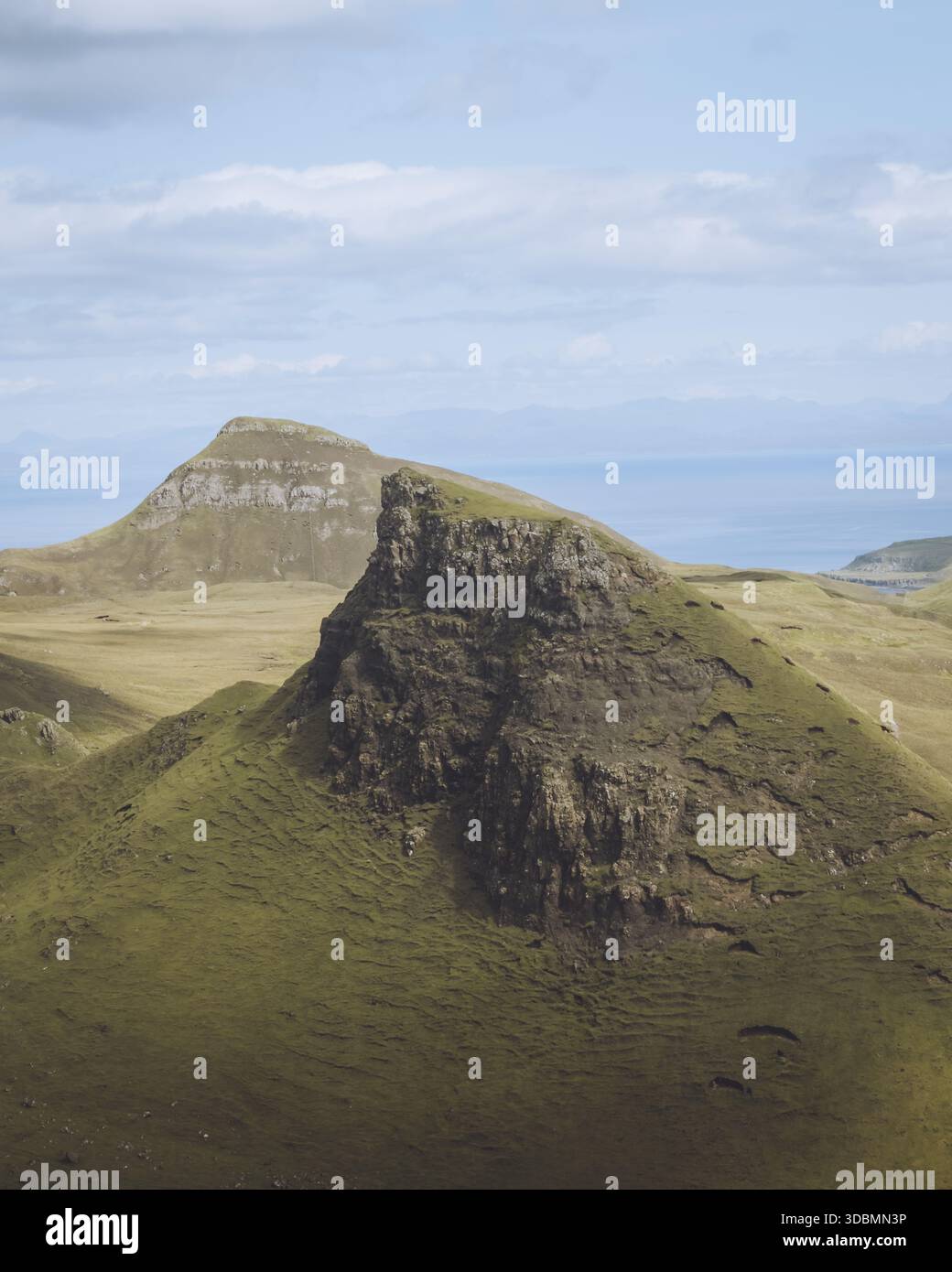 Blick auf dramatisches, zerklüftetes Gelände mit markanten grünen Hügeln und imposanten, felsigen Gipfeln unter einem riesigen Himmel, Quiraing, Portree, Schottland, Vereinigtes Königreich Stockfoto