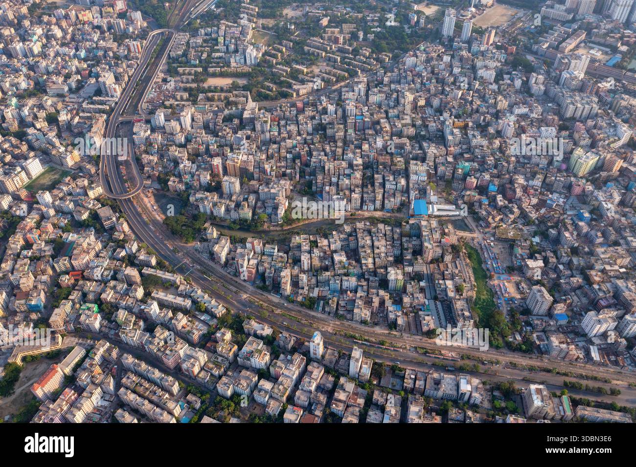 Luftaufnahme einer dicht gepackten Stadtlandschaft, in der sich Gebäude eng aneinander Reihen, geteilt durch kurvige Eisenbahnlinien, Dhaka, Dhaka Division, B Stockfoto