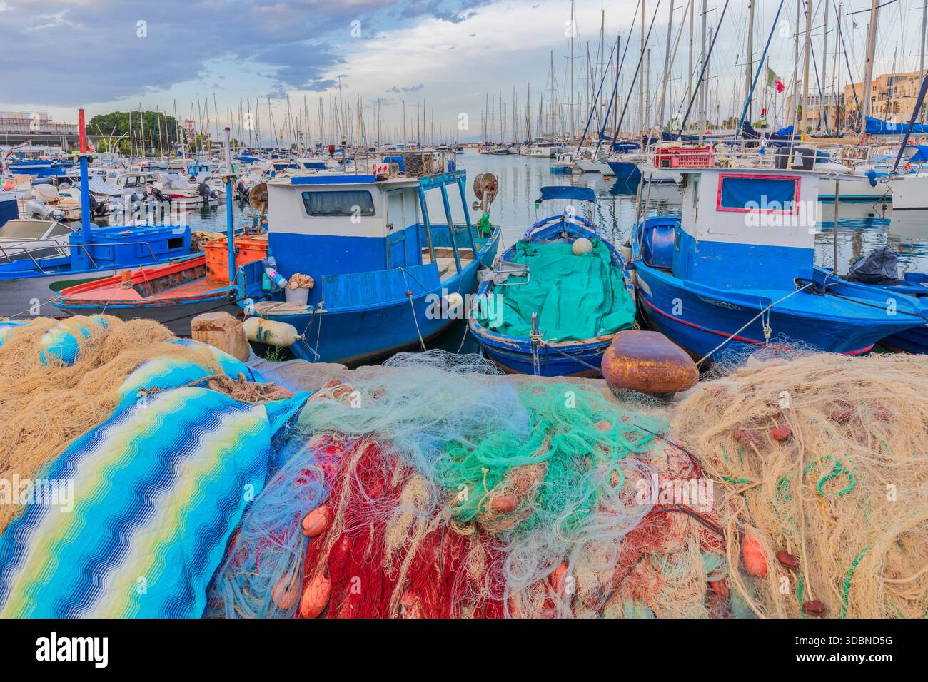 Fischernetze und Boote liegen im kleinen Hafen von La Cala, Palermo, Sizilien, Italien Stockfoto