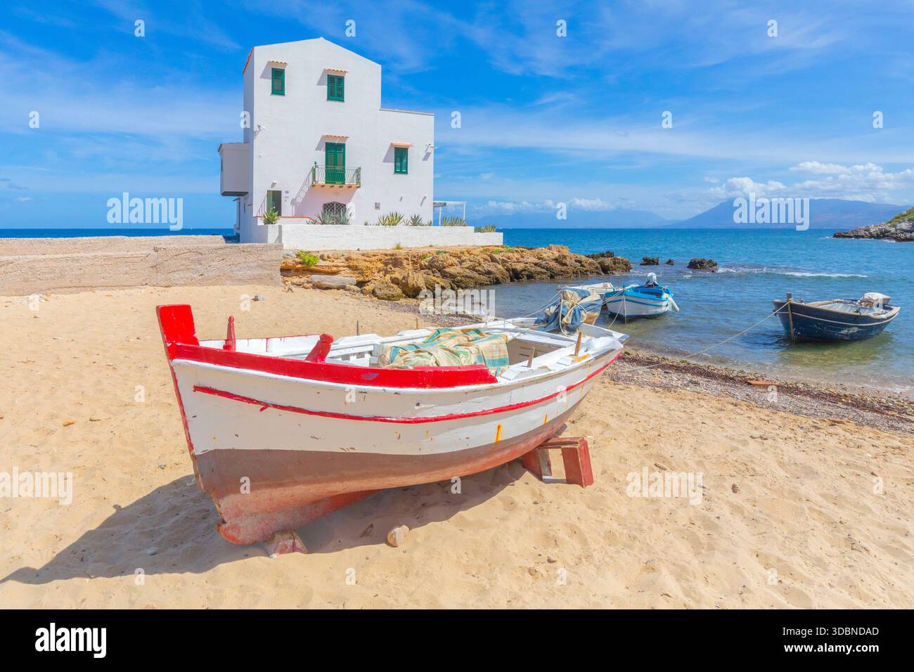 Ruderboote am Sandstrand von Sant'Elia, Santa Flavia, mit einem weißen Haus am Meer, in der Nähe von Palermo, Sizilien, Italien Stockfoto